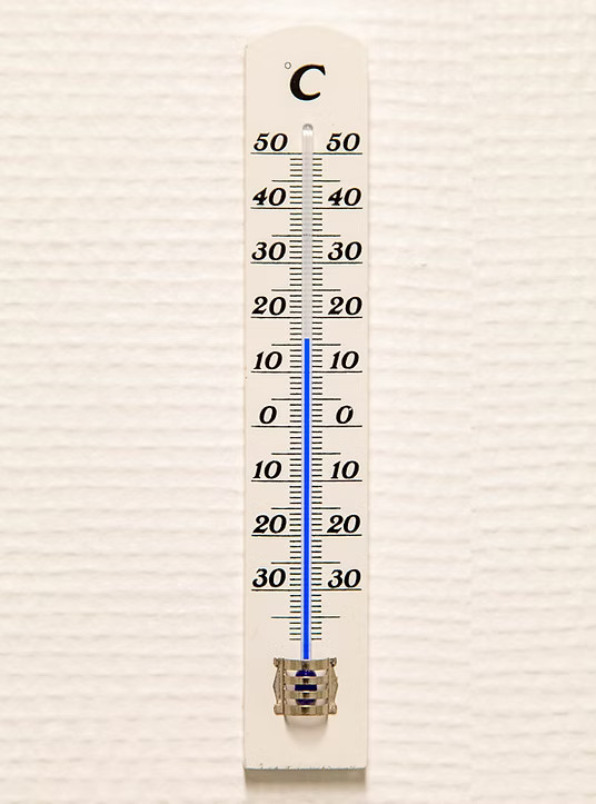 Termometer på væggen, der viser en stabil og opvarmet temperatur i vores faciliteter