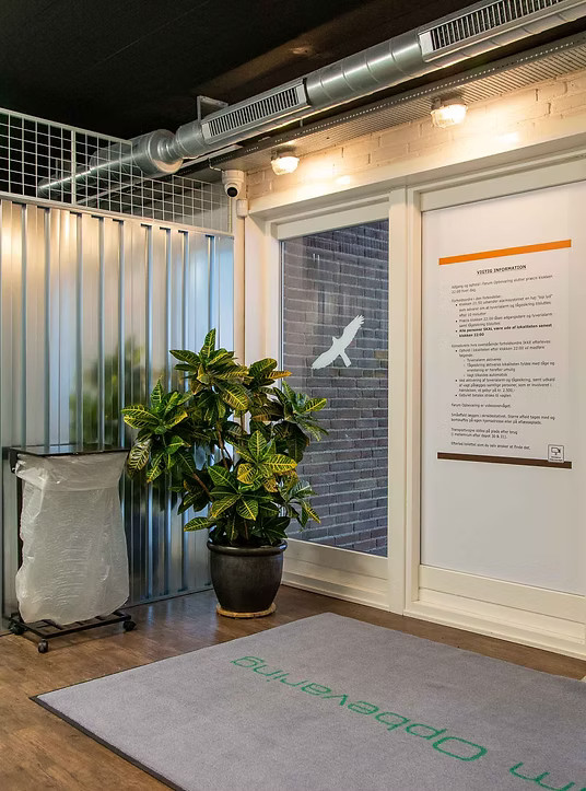 Indbydende indgangsområde med informationstavle og ventilation